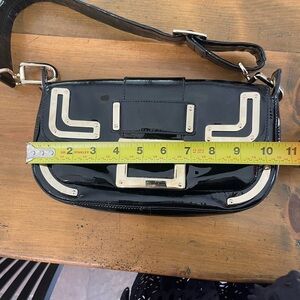 black patent leather Roger Vivier bag with signature gold buckle